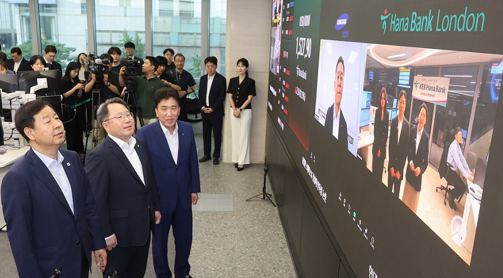 ▲ 하나은행 런던지점 출신 인사들이 다수 활동하는 KUFA는 국내 금융권 및 정부 관계자들과의 교류를 통해 한국 금융시장과의 접점을 넓혀가고 있다. 사진은 지난 7월 6일 구윤철 부총리 겸 재정경제부 장관(왼쪽부터), 권민수 한국은행 부총재보, 함영주 하나금융그룹 회장이 서울 중구 하나은행 본점 딜링룸에서 하나은행 런던지점 직원들과 화상으로 대화하는 모습. [사진=연합뉴스]