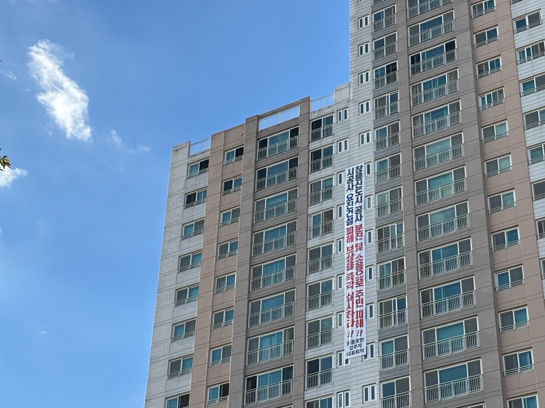▲ 현재 창릉신도시 조성 공사 현장 곳곳에서 절·성토 작업이 진행되면서 비산먼지와 소음 등으로 인한 인근 주민들의 불편도 이어지고 있다. 사진은 창릉신도시 공사 현장과 맞닿아 있는 아파트 외벽에 공사 피해를 호소하는 현수막이 걸려 있는 모습. ⓒ르데스크